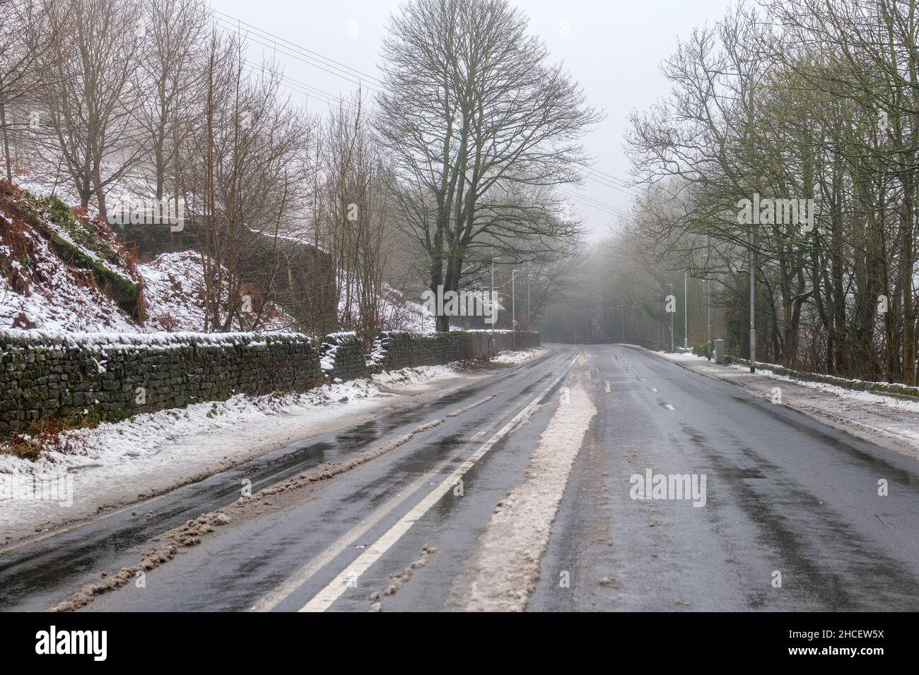 Vider la voie glacée A660 Otley Road avec de la neige et de la glace créant de mauvaises conditions de conduite.Pas de voitures ni de personnes. Banque D'Images
