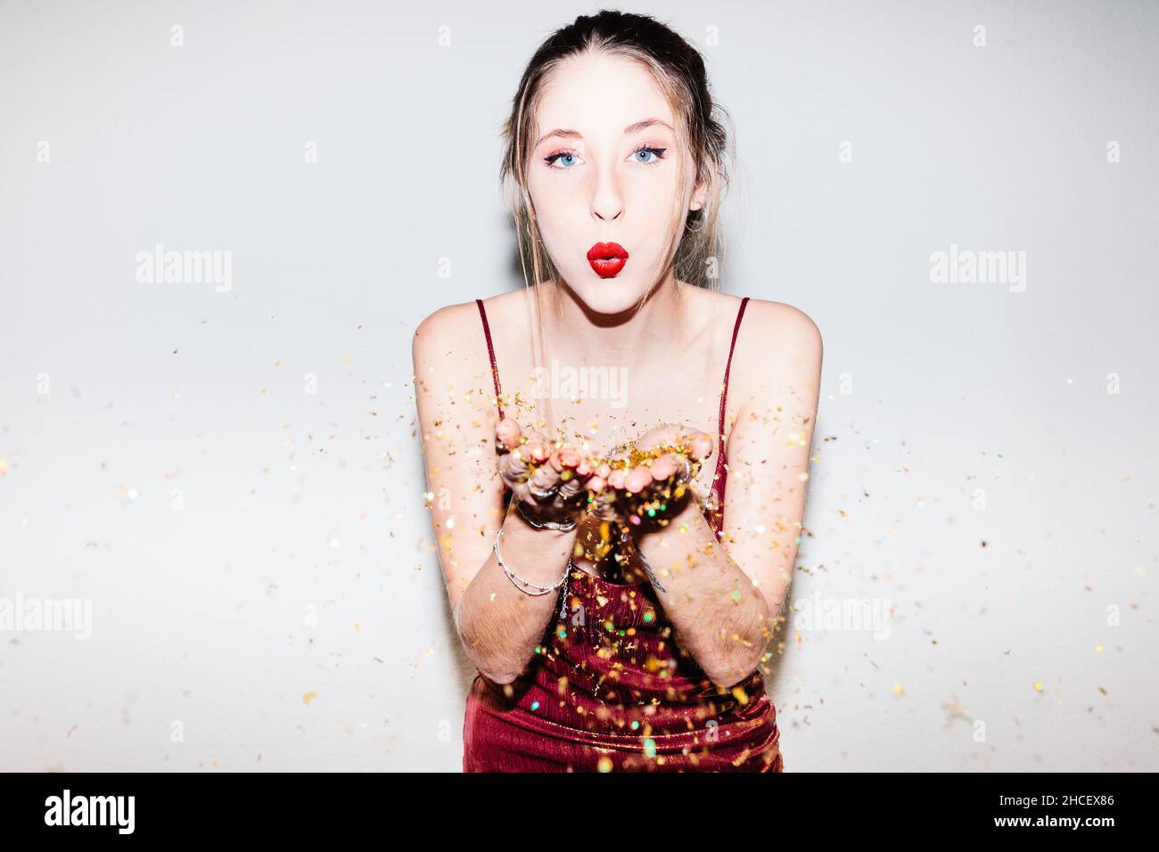 Jeune femme célébrant son 21e anniversaire illuminée par un flash dur. Banque D'Images
