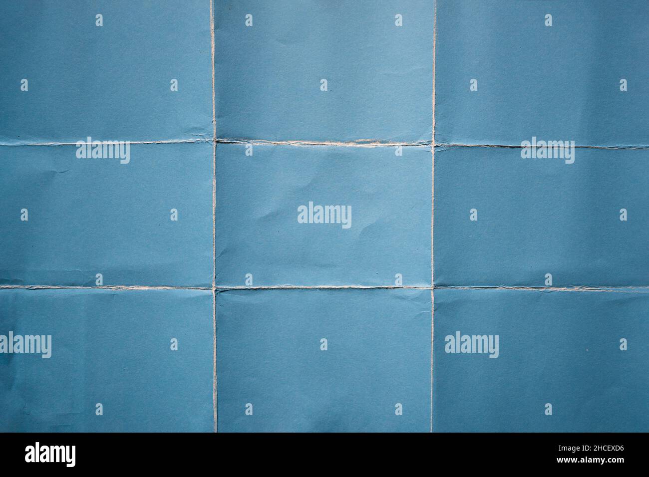 Papier bleu plié en arrière-plan de neuf fractions Banque D'Images
