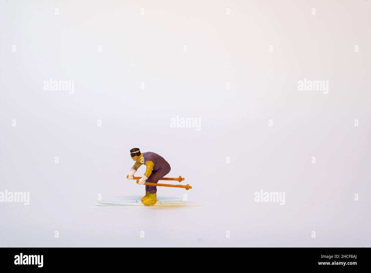 Skieur miniature en action sur fond blanc - espace de copie Banque D'Images