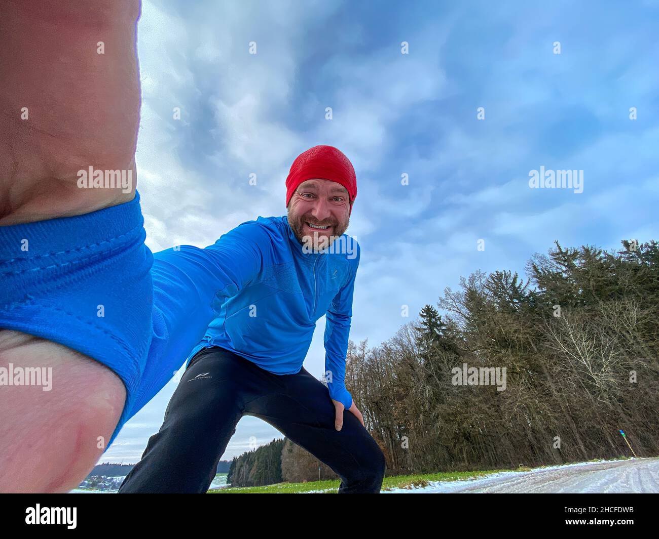 Homme de course à pied avec casquette rouge pendant l'hiver Banque D'Images