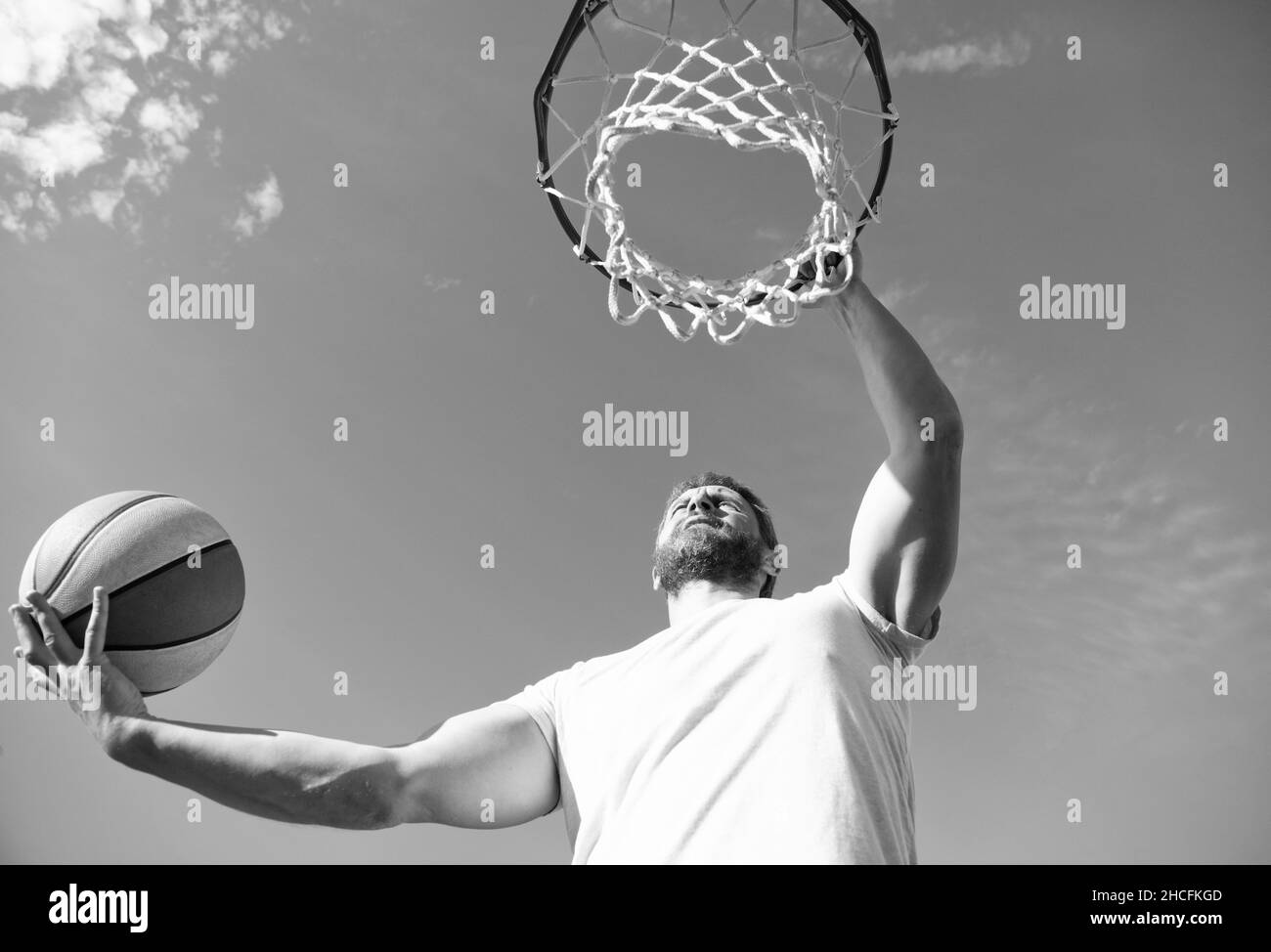 homme jouer au basket-ball extérieur. homme sauter pour lancer le ballon. gars jouer au basket-ball. Banque D'Images