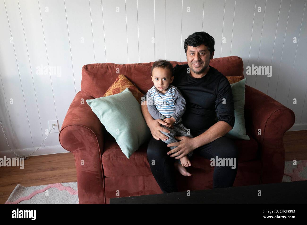 Austin Texas USA, novembre 2021 : un père et un jeune fils afghans posent dans leur nouvel appartement près de l'Université du Texas à Austin.Les réfugiés fuyant la tourmente en Afghanistan continuent d'être réinstallés au Texas, avec de nombreux hommes célibataires et de grandes familles avec des enfants qui déménagent dans des appartements à travers Austin.Les groupes religieux et autres groupes à but non lucratif ont intensifié leurs efforts pour coordonner les efforts visant à fournir des maisons à des centaines de réfugiés.©Bob Daemmrich Banque D'Images