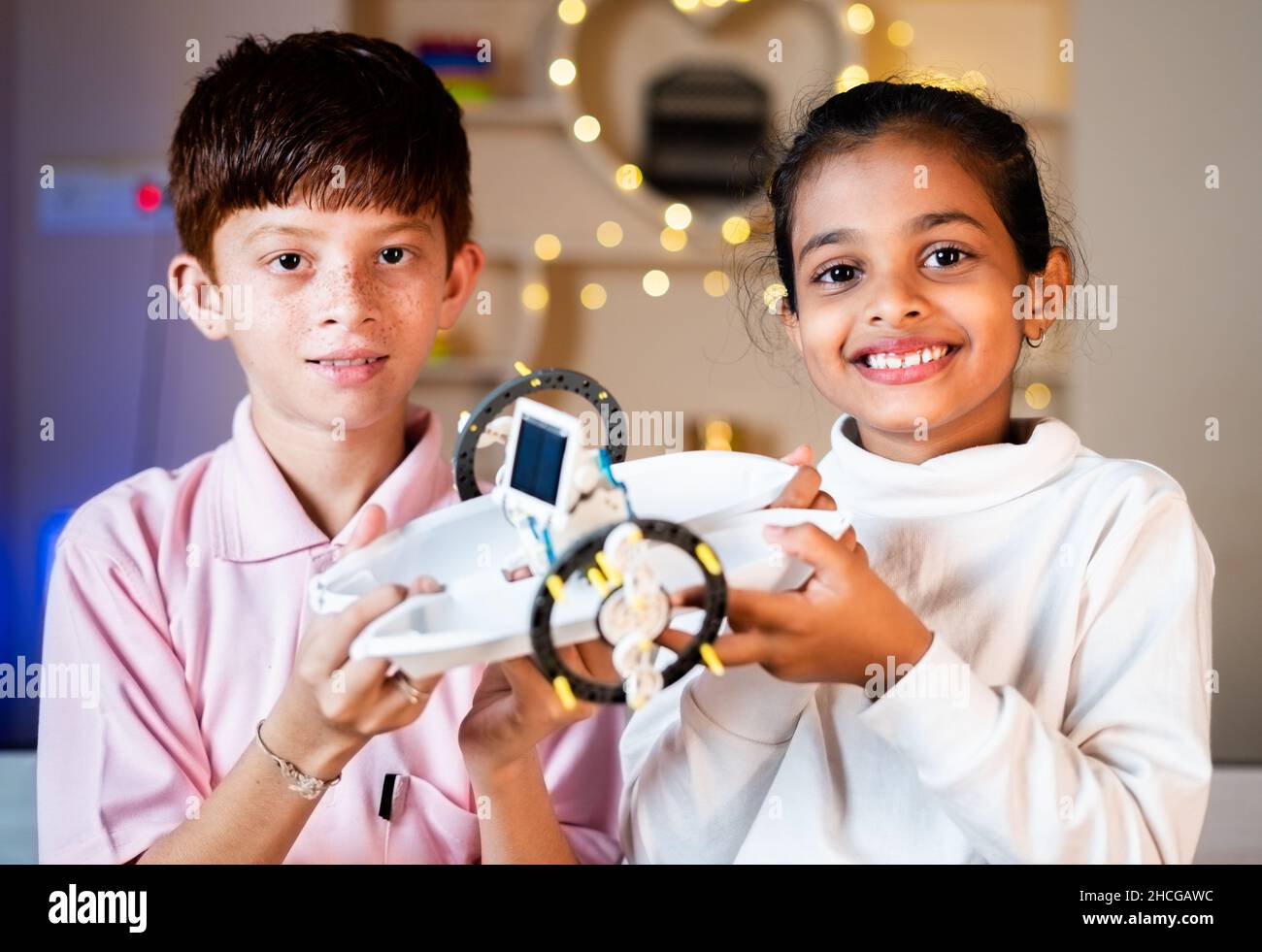 Portrait de divers enfants avec des jouets robotiques de bricolage à la main regardant avec confiance l'appareil-photo - concept de développement de compétences, intelligent et créatif Banque D'Images