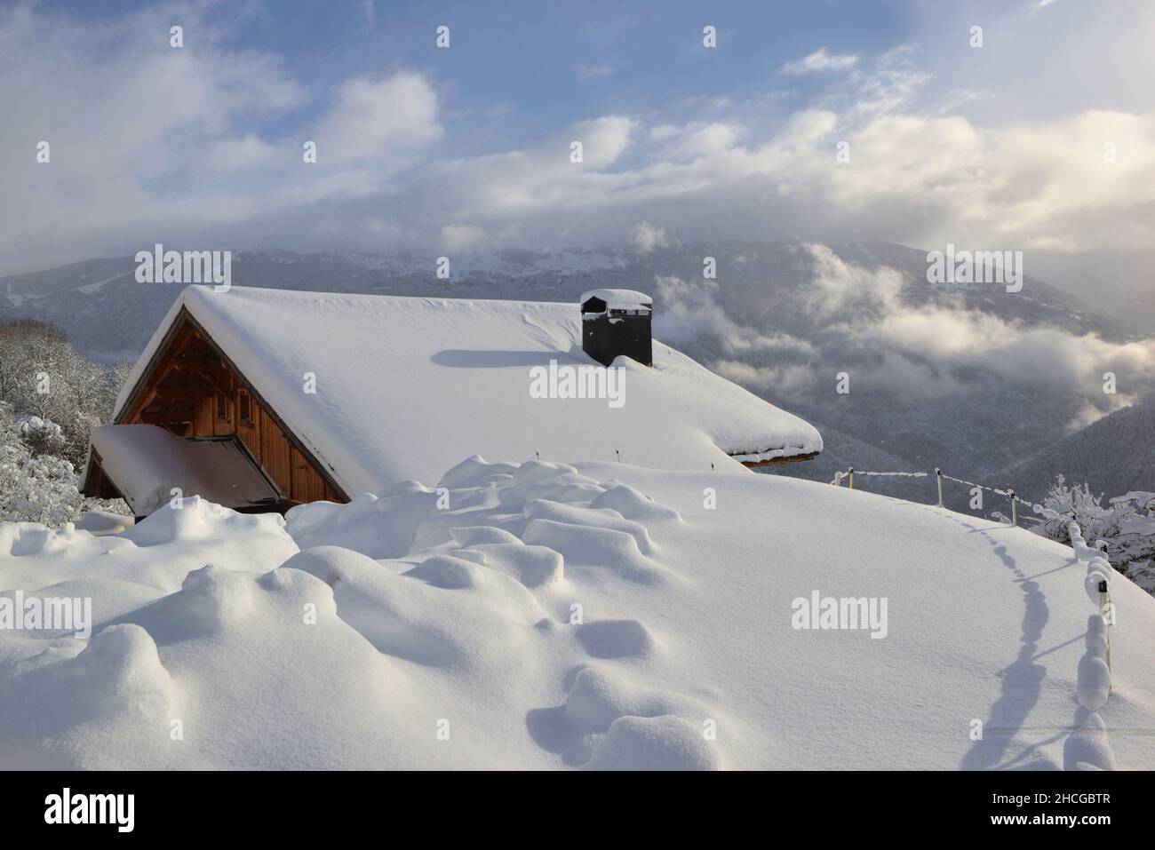 chalet en bois dans un village alpin recouvert de neige fraîche dans un paysage de montagne Banque D'Images