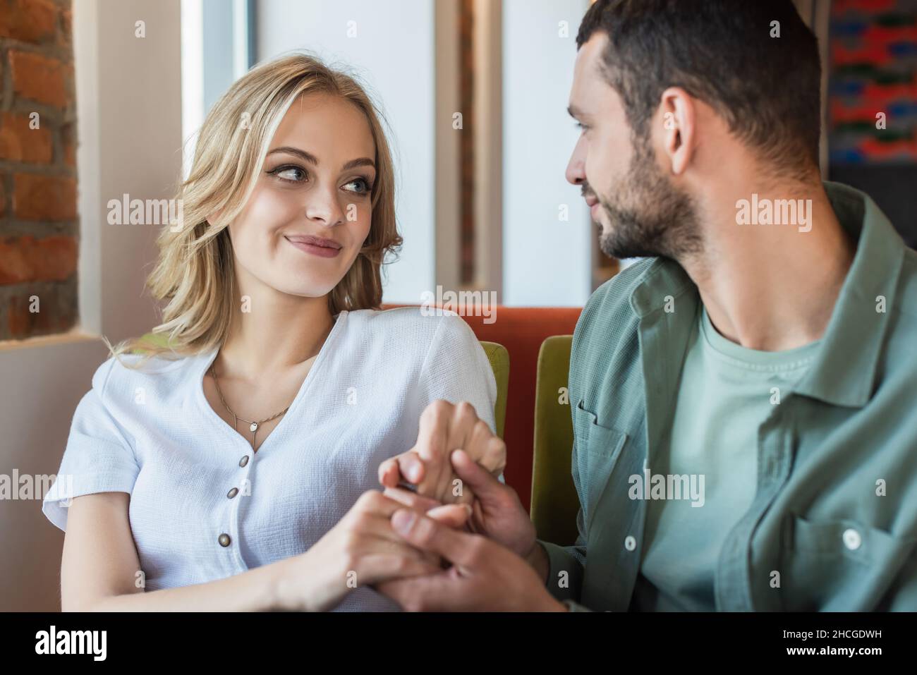 un jeune couple heureux se regardant les uns les autres et se tenant les mains pendant une période romantique au restaurant Banque D'Images