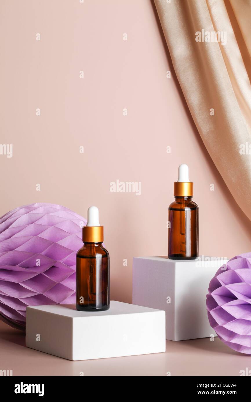 Essence de sérum sur podium sur fond beige avec décor textile et papier nid d'abeille.Cosmétiques pour le soin de la peau. Concept de présentation du produit Banque D'Images