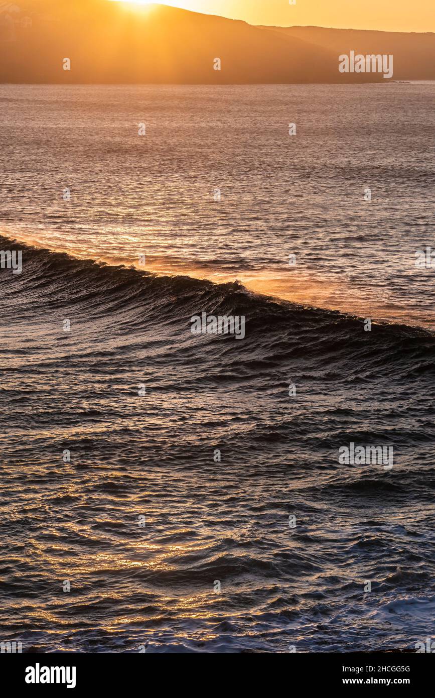 Lumière dorée intense d'un spectaculaire coucher de soleil sur la baie de Fistral à Newquay, en Cornouailles. Banque D'Images