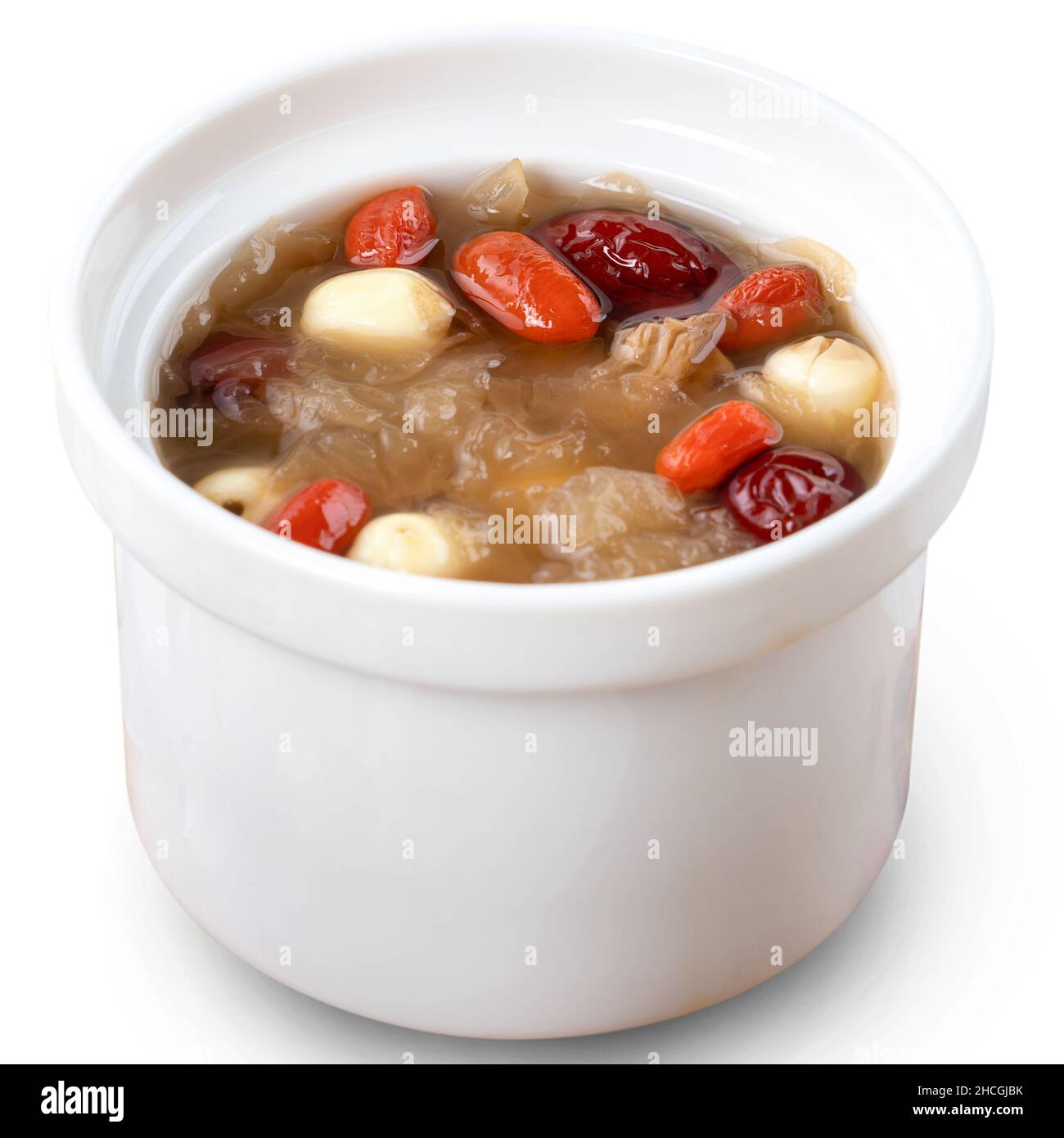 Gros plan de la soupe traditionnelle chinoise de champignons blancs de neige douce avec graines de lotus, dattes rouges (jujujube) et baies de carcajou (goji, gogyberry) isolées sur le bac blanc Banque D'Images