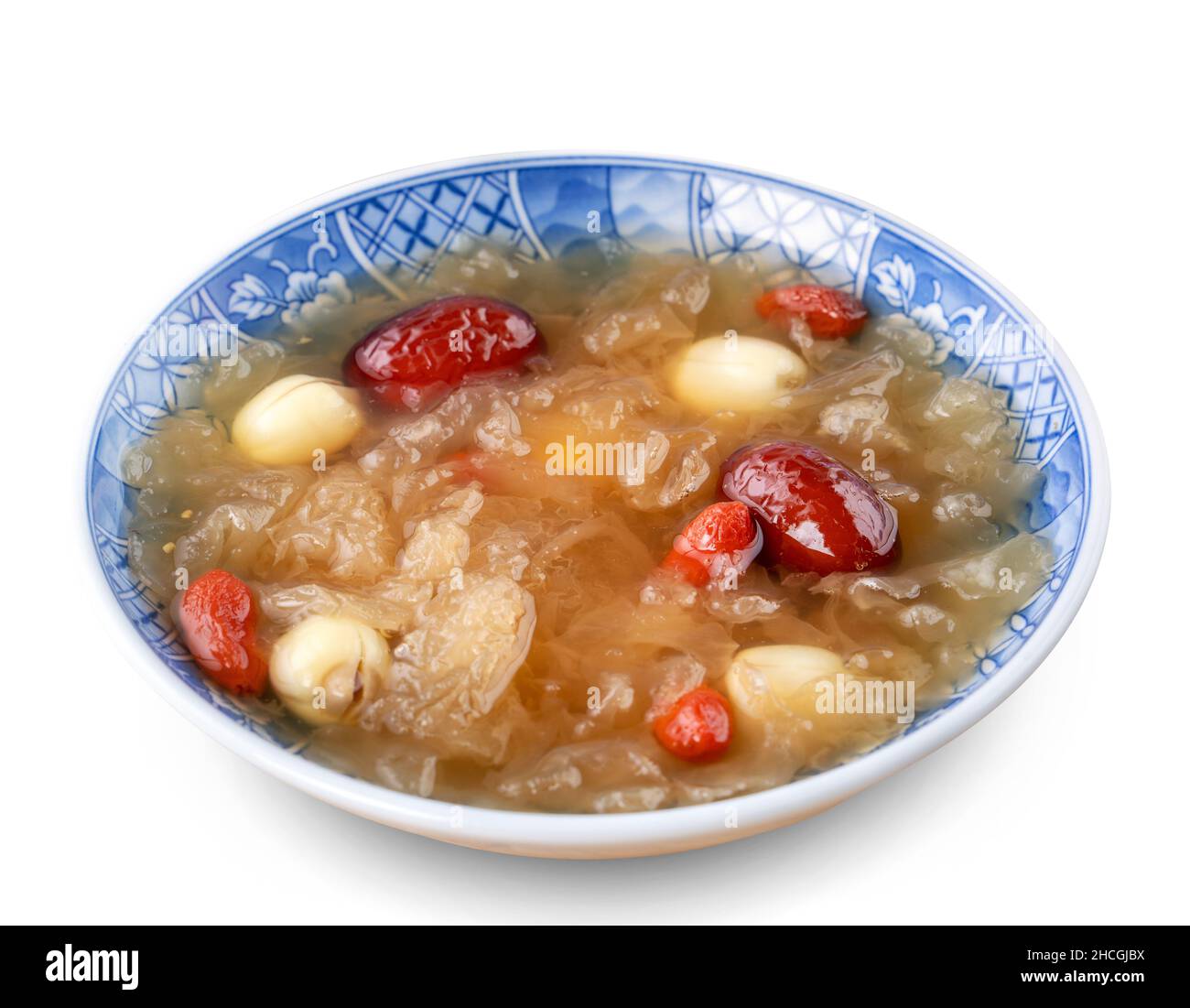 Gros plan de la soupe traditionnelle chinoise de champignons blancs de neige douce avec graines de lotus, dattes rouges (jujujube) et baies de carcajou (goji, gogyberry) isolées sur le bac blanc Banque D'Images