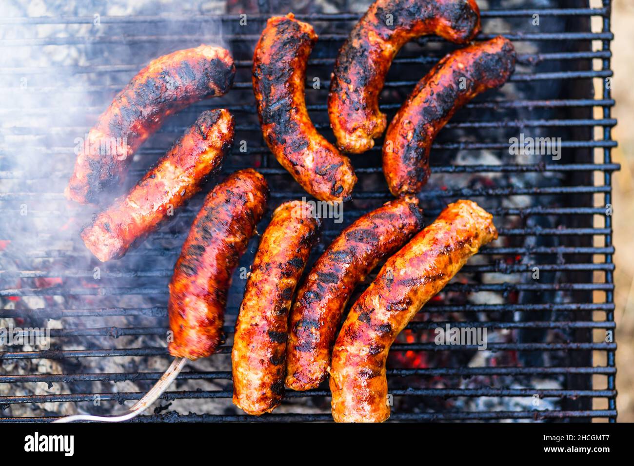 Griller des saucisses sur le barbecue. De délicieuses saucisses sur le gril  à charbon de bois Photo Stock - Alamy