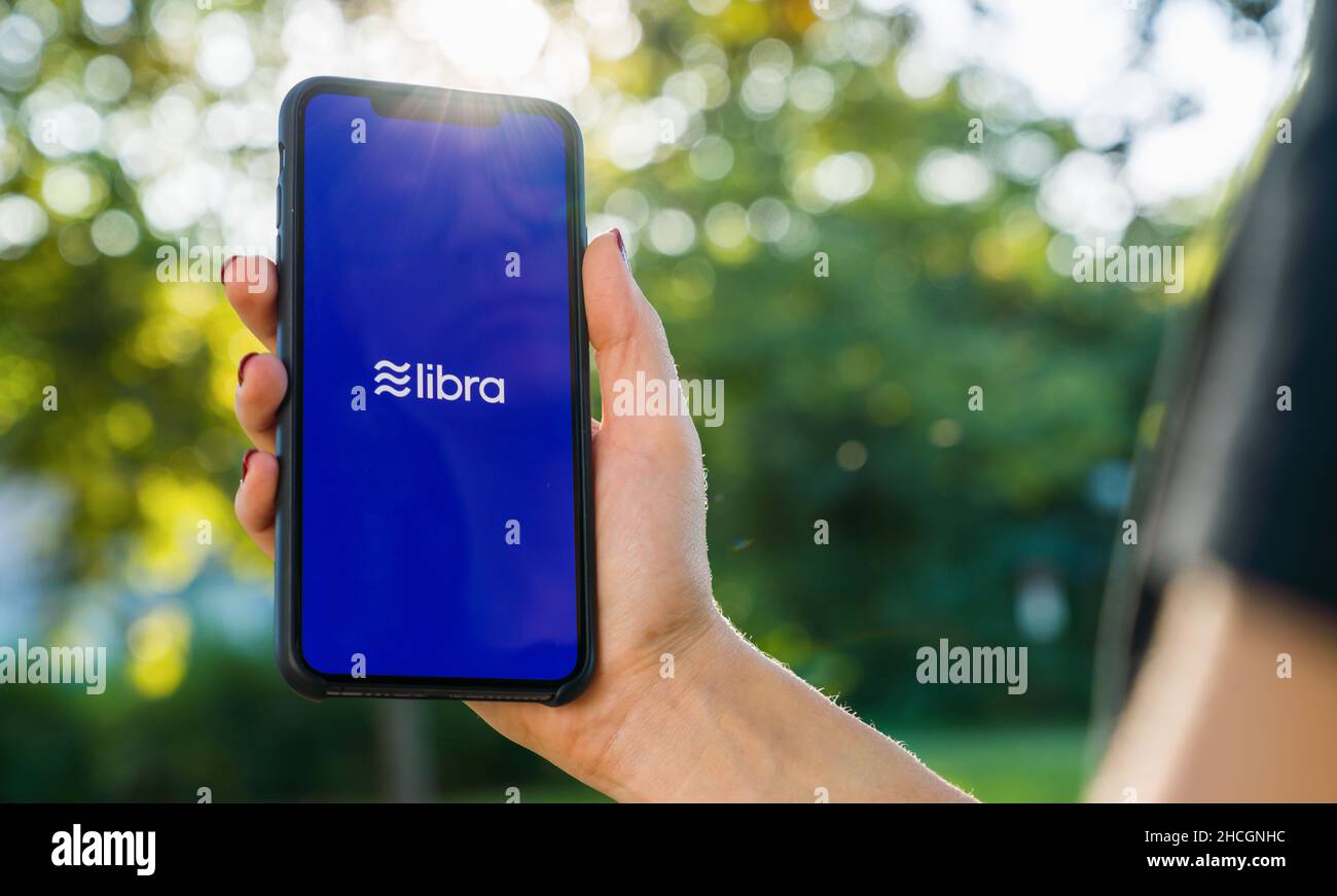 Femme tenant main iphone X avec le logo de la Balance dans le parc.LiBalance Facebook crypto-monnaie et bitcoin crypto-monnaie smartphone Share, LiBalance coins Banque D'Images