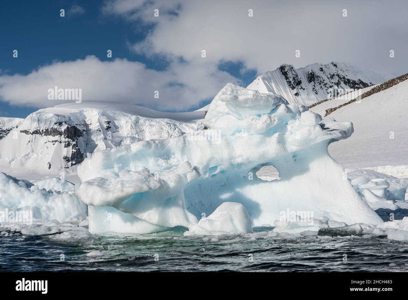 Une photographie de paysage d'un iceberg et d'un fond de montagnes enneigées sur l'île de Danco, en Antarctique Banque D'Images