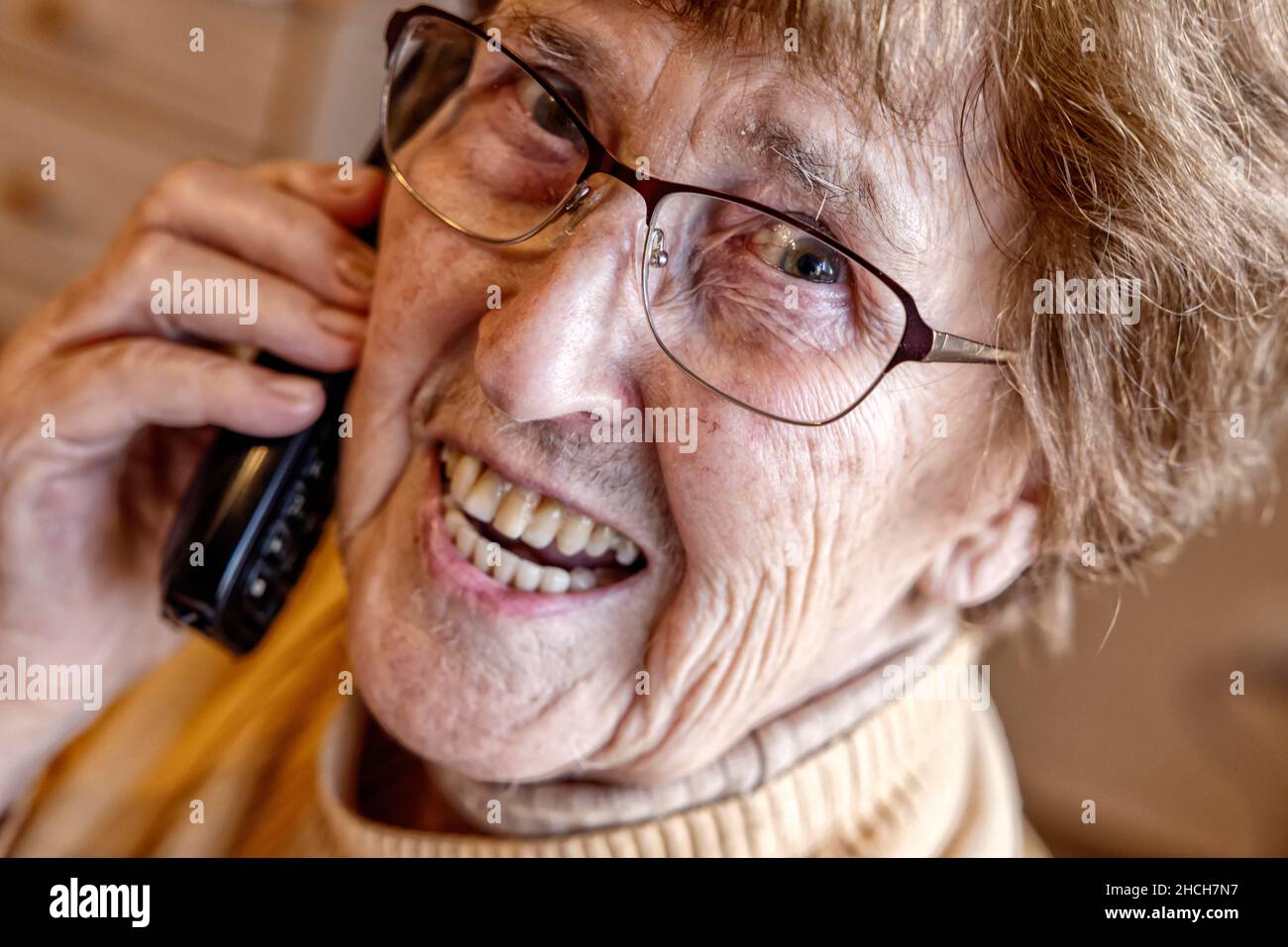 Senior à la maison riant au téléphone, Cologne, Rhénanie-du-Nord-Westphalie, Allemagne Banque D'Images
