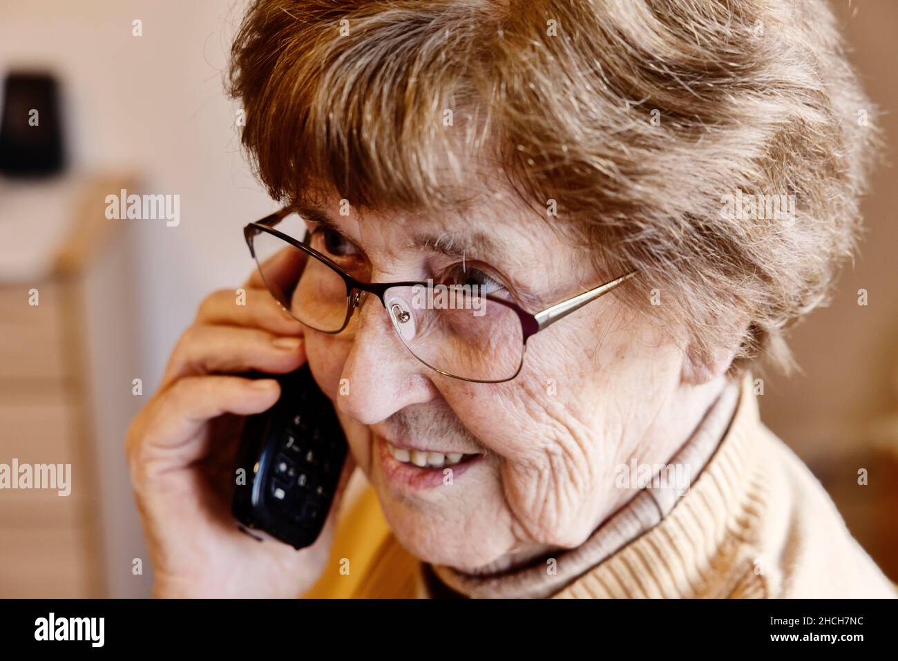 Femme âgée à la maison parlant au téléphone, Cologne, Rhénanie-du-Nord-Westphalie, Allemagne Banque D'Images