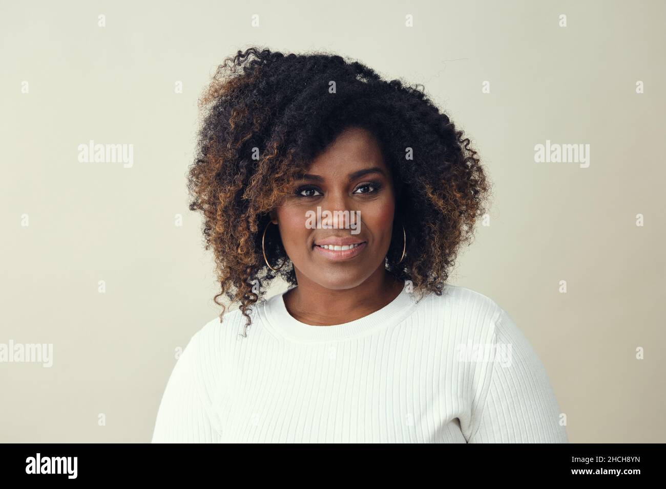 Portrait d'une belle femme avec des cheveux bruns sursélectionnés sur fond blanc Banque D'Images