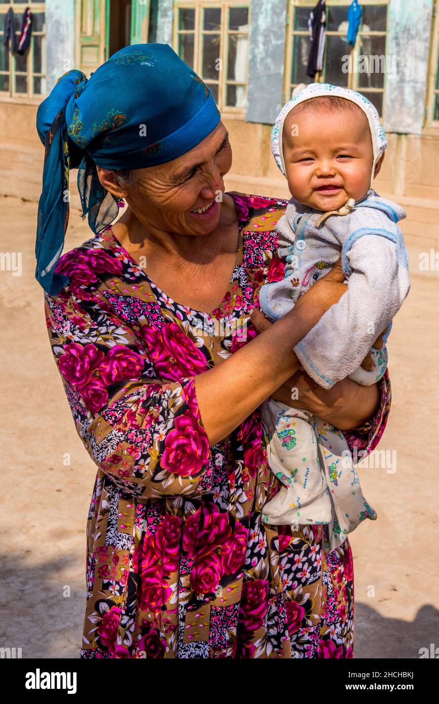 Femme avec tout-petit, village, sur la route dans la campagne, Ouzbékistan, Ouzbékistan Banque D'Images