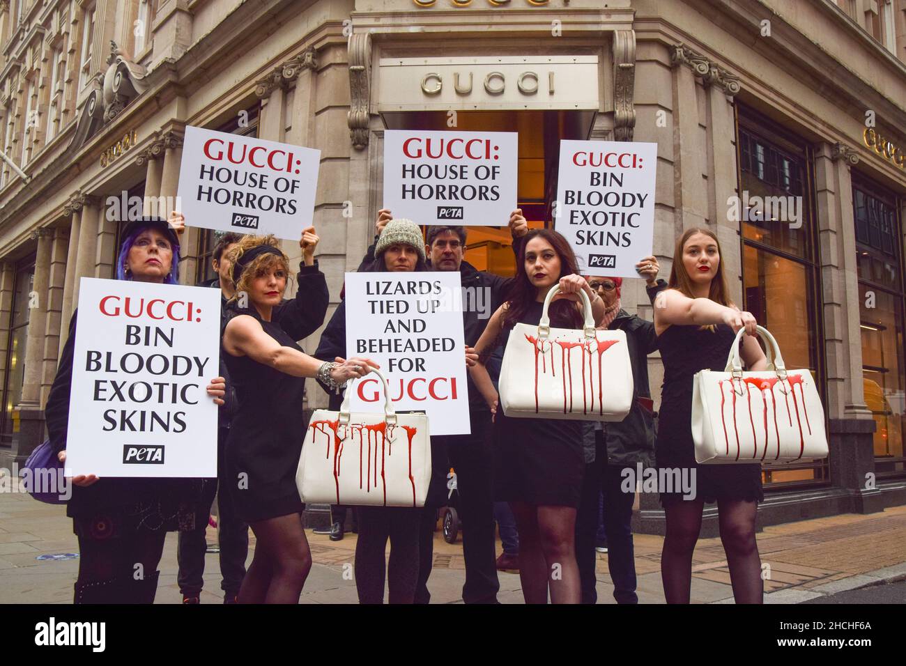 Londres, Royaume-Uni 23rd décembre 2021.Les militants du PETA se sont rassemblés devant le magasin Gucci de Bond Street et ont organisé une « passerelle » avec des sacs à main éclatés de faux sang pour protester contre l'utilisation de peaux de lézard dans les produits de Gucci.L'enquête de PETA a montré que les fournisseurs de peau de lézard tombent bien en dessous des normes de bien-être des animaux et causent d'énormes souffrances pour les animaux. Banque D'Images