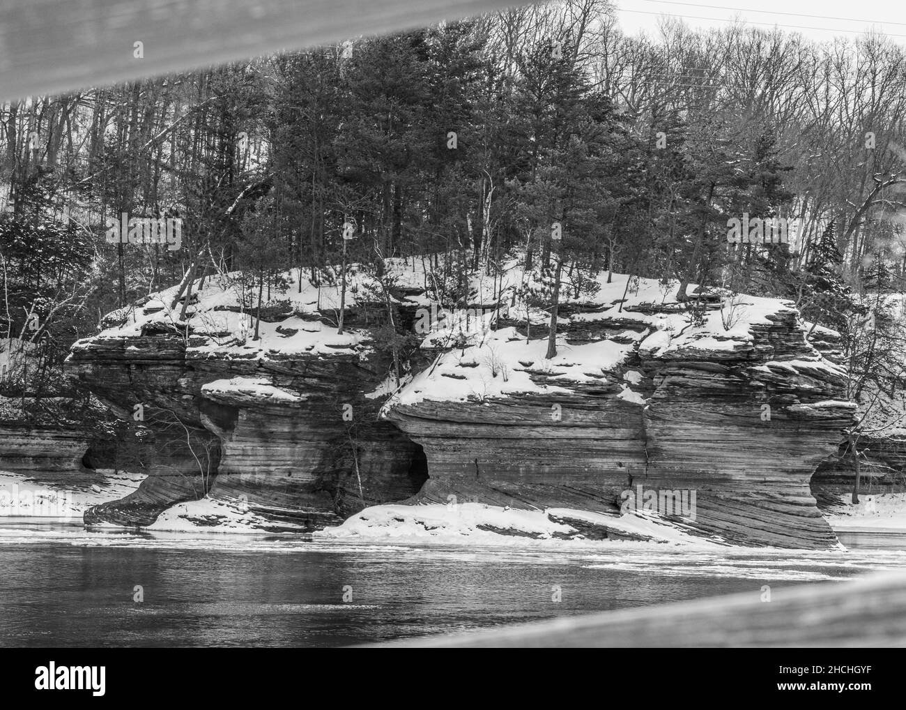 Photo en niveaux de gris d'un lac gelé et d'une forêt enneigée dans le Wisconsin Banque D'Images