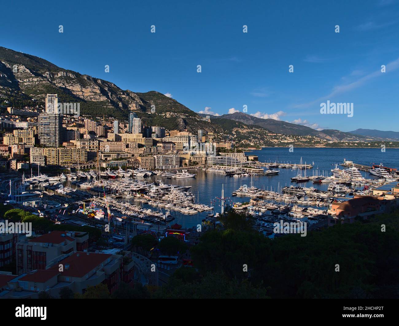 Belle vue panoramique de la Principauté de Monaco au soleil de l'après-midi avec port de plaisance Port Hercule, foire et immeubles de haute hauteur. Banque D'Images