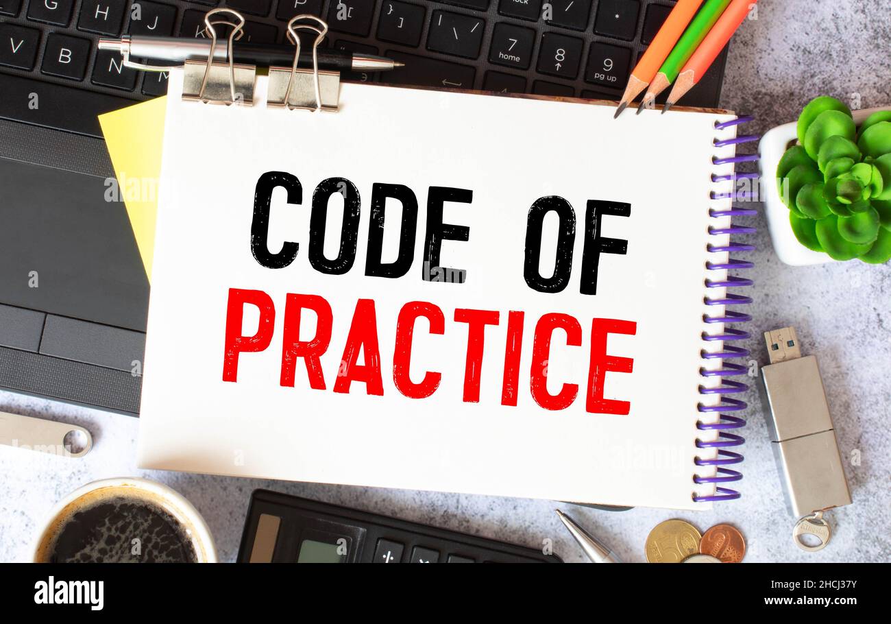 Texte du Code de pratique écrit sur un bloc-notes avec des crayons. Banque D'Images