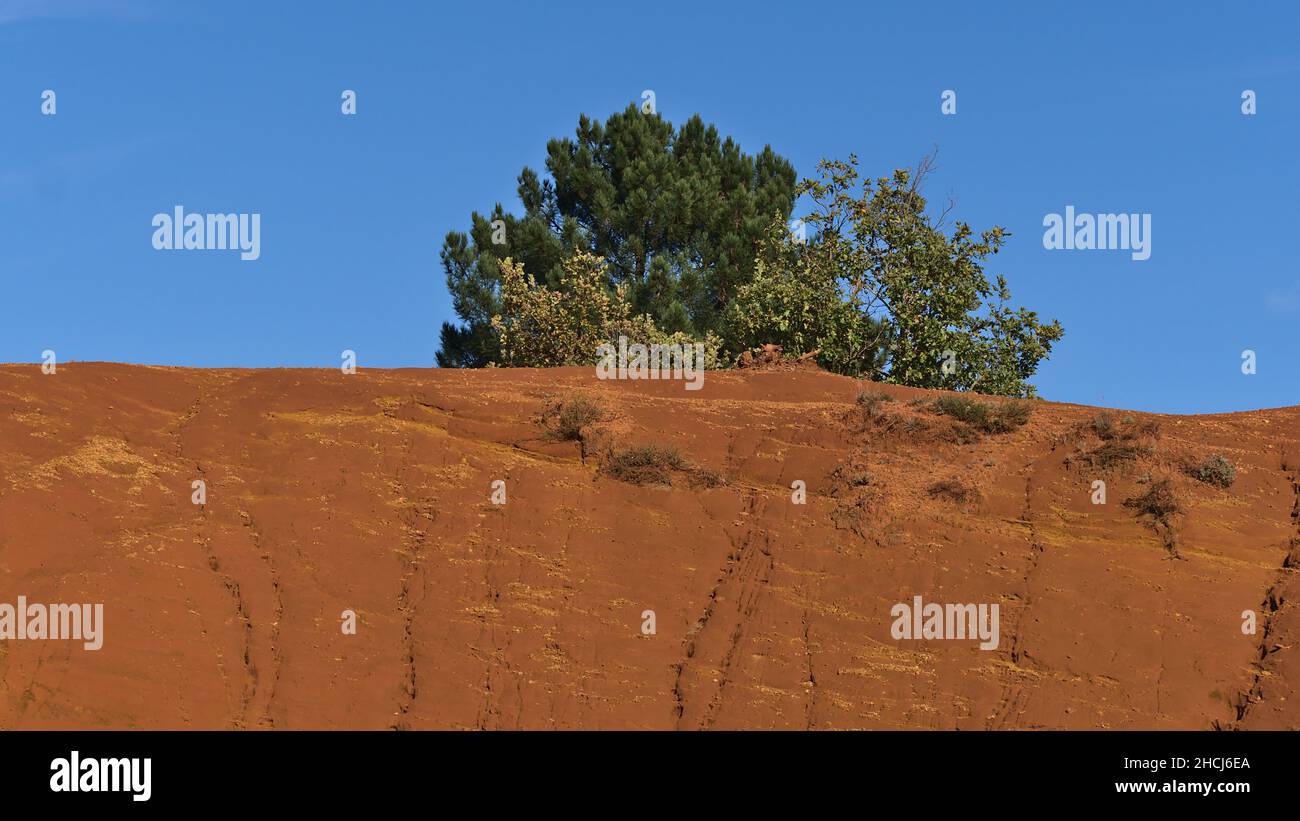 Belle vue sur les rochers ocre de couleur orange au Colorado provençal près de Rustrel dans la vallée du Luberon, Provence, France le jour ensoleillé de la saison d'automne. Banque D'Images