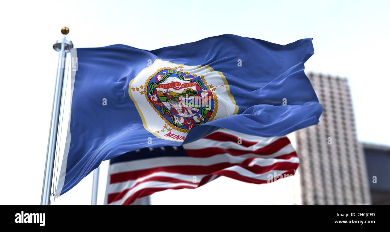 Le drapeau de l'état américain du Minnesota agitant dans le vent avec le drapeau américain flou en arrière-plan.Le Minnesota a été admis à l'Union en mai Banque D'Images