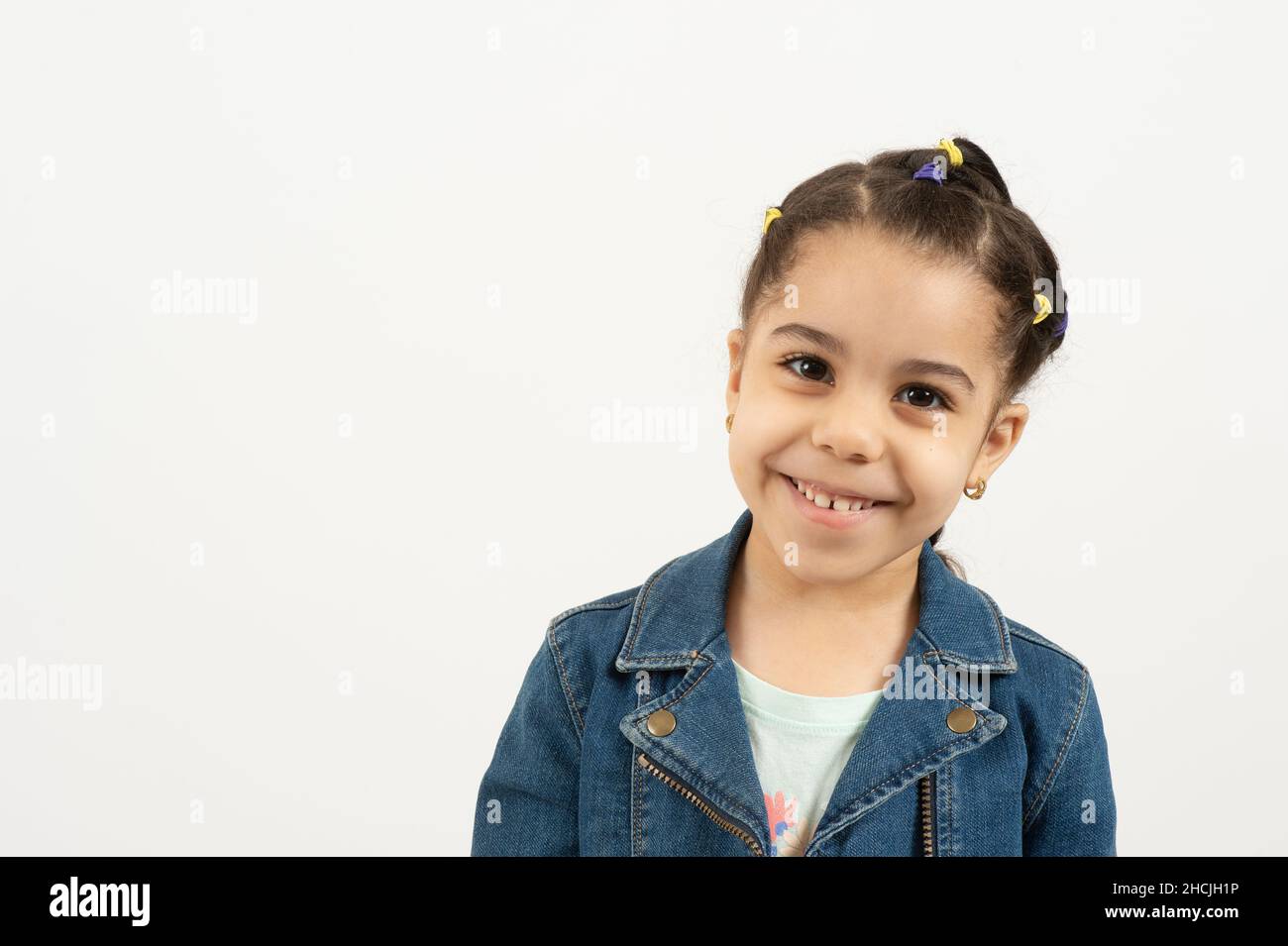 Gros plan portrait d'une fille de 4 ou 5 ans, souriant, fond blanc Banque D'Images