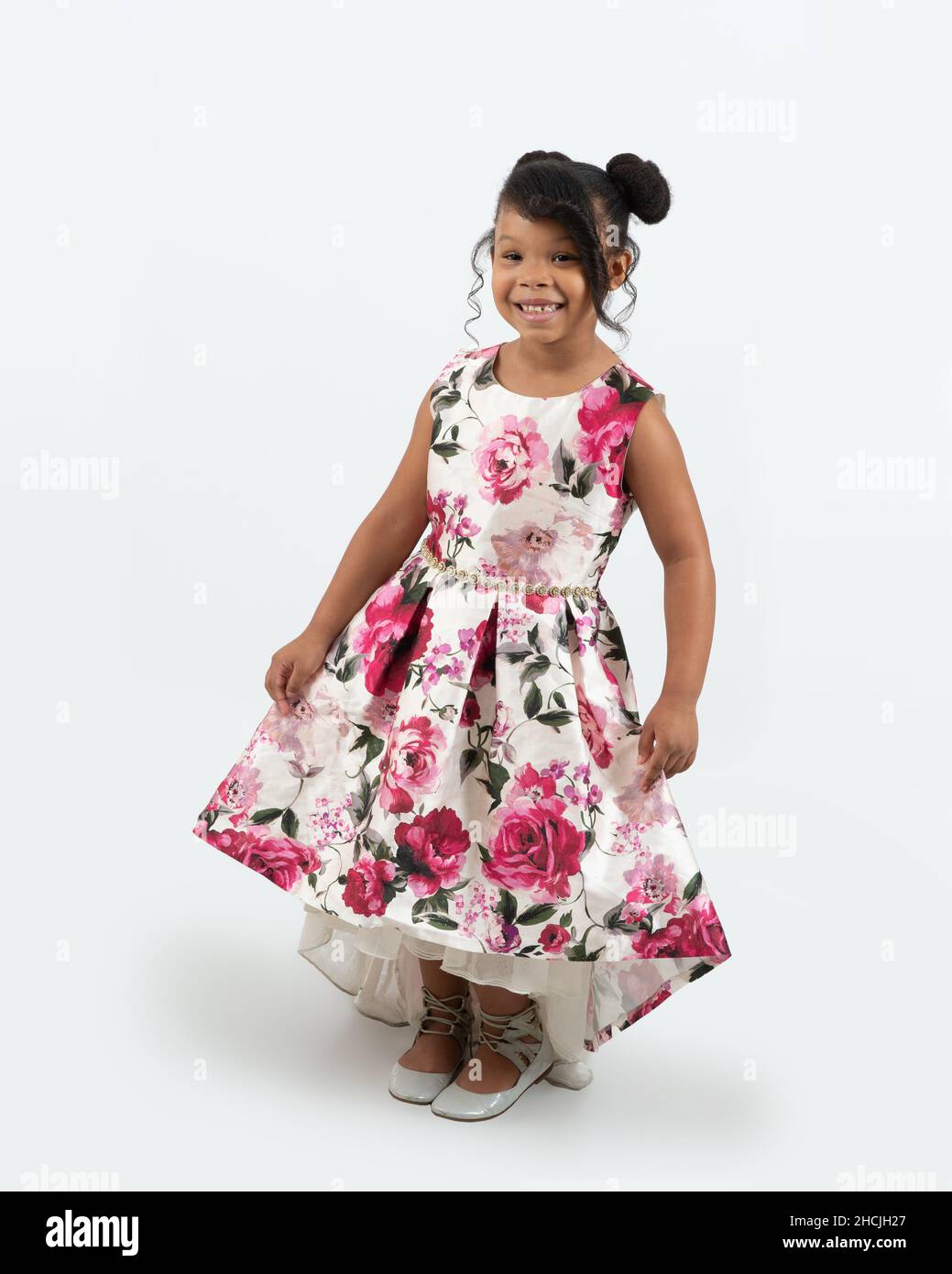 portrait de pleine longueur de fille de 4 ou 5 ans, souriant, fond blanc, en robe habillée Banque D'Images