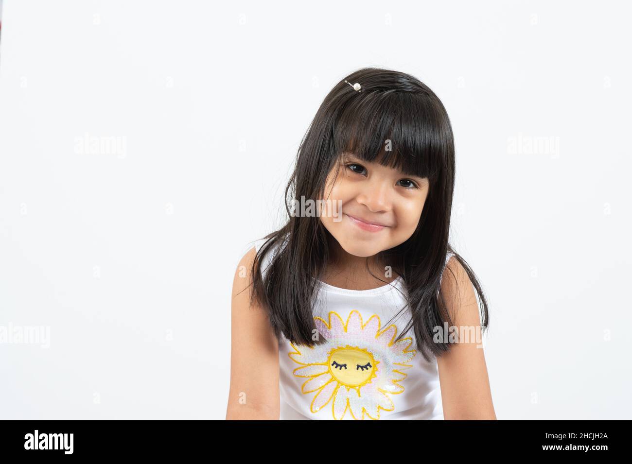 Gros plan portrait d'une fille de 4 ou 5 ans, souriant, fond blanc Banque D'Images