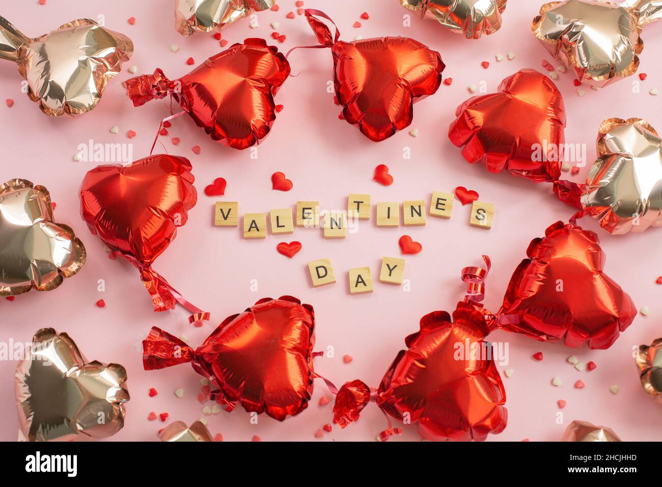 Le mot Saint-Valentin des blocs de lettres et des coeurs rouges ballons feuille autour.Romantique, concept de la Saint-Valentin.Vue de dessus. Banque D'Images