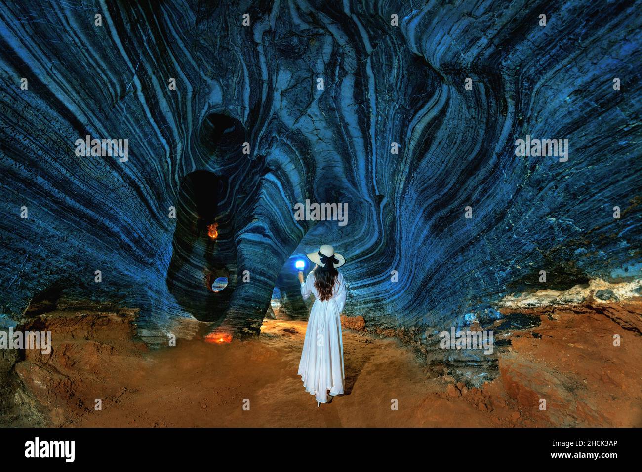 Belle fille en robe blanche marchant dans la grotte bleue, Thaïlande. Banque D'Images
