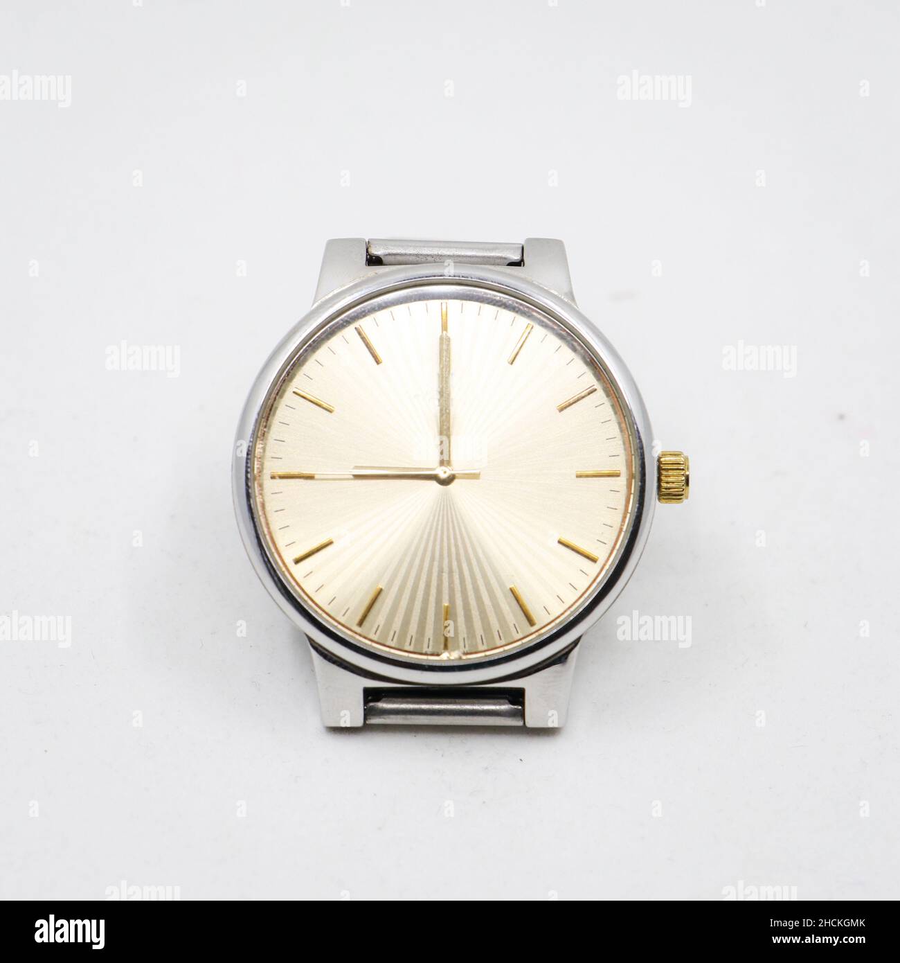 montre analogique en acier inoxydable argenté avec cadran rond doré, symbole de luxe vintage isolé sur fond blanc Banque D'Images