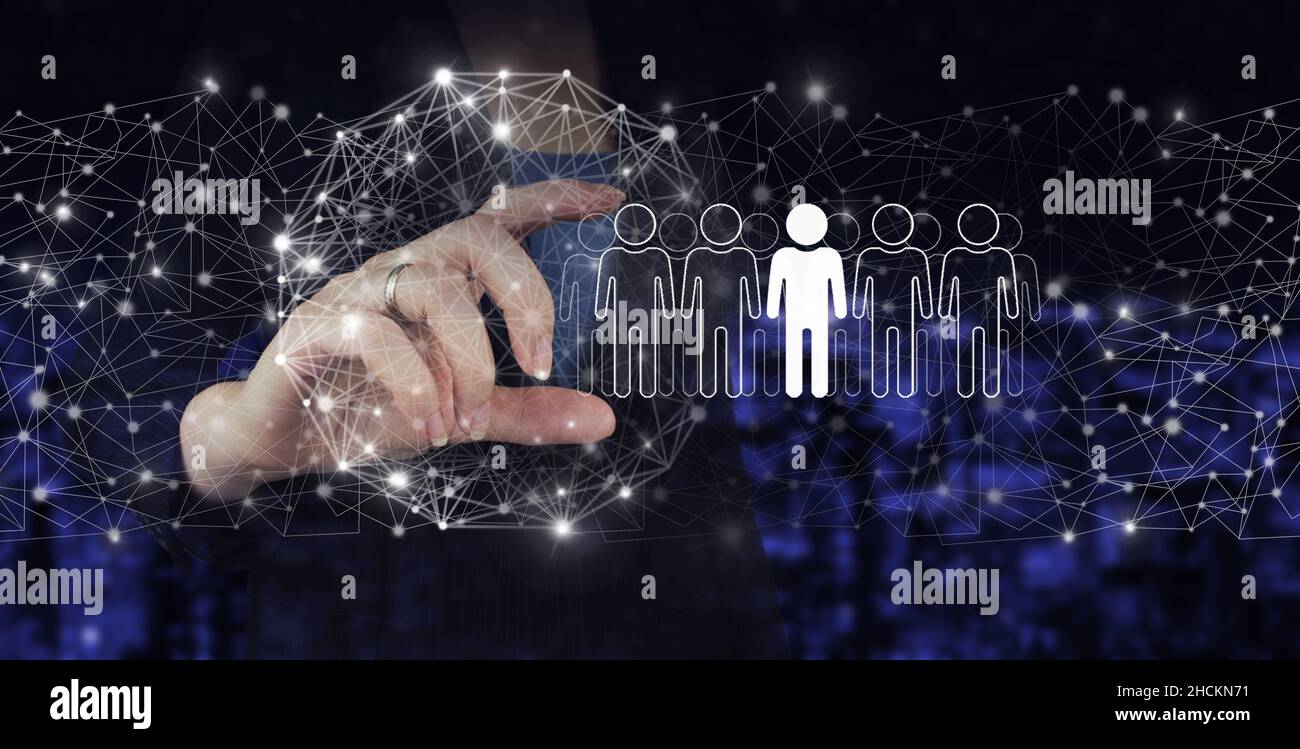 RH Ressources humaines, relations avec les peuples structure organisationnelle.Main tenir l'hologramme numérique humain, leader signe sur ville sombre flou arrière-plan.Recruteurs Banque D'Images