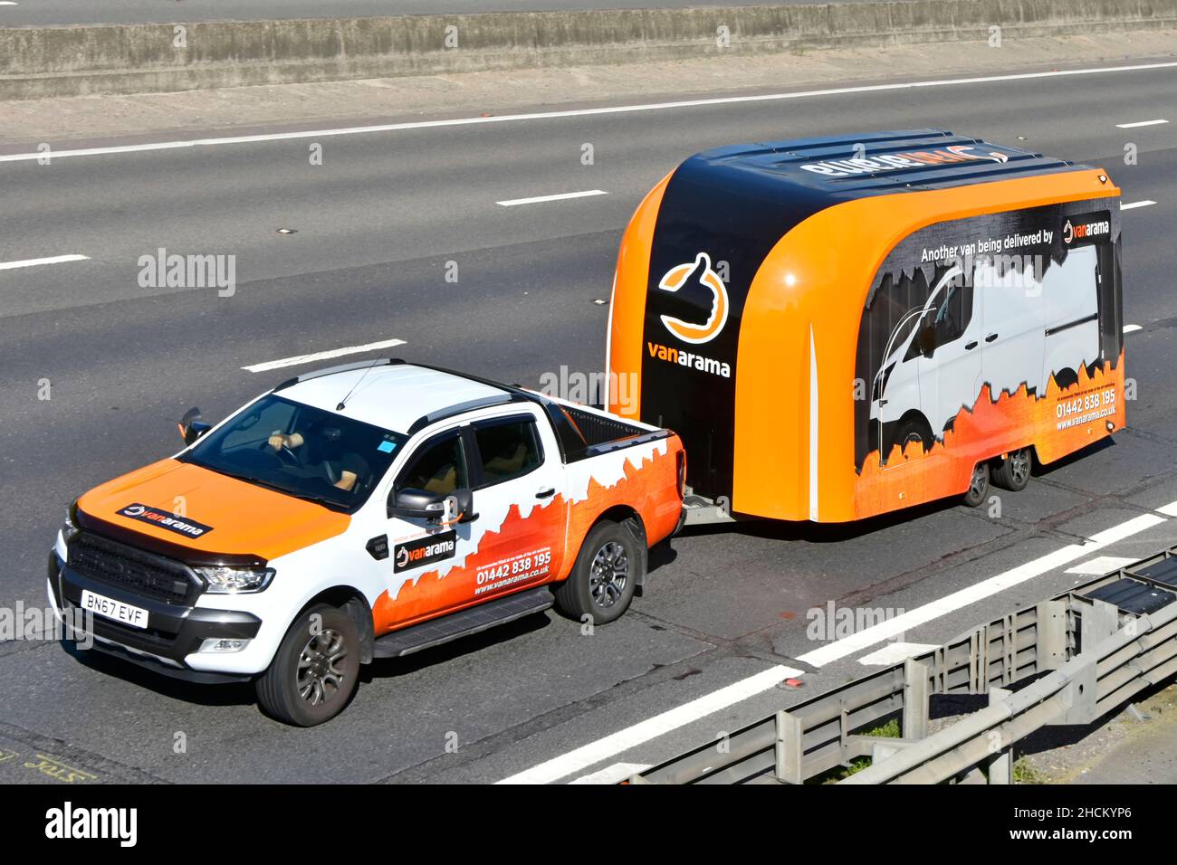 Graphiques colorés vue latérale et avant camionnette et remorque publicité Vanarama activité de location de véhicules commerciaux personnels sur l'autoroute britannique Banque D'Images