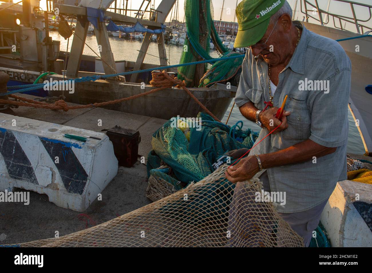 Europa, Italia, Sardegna, Porto Torres, Pescatore ripara le reti rotte Banque D'Images