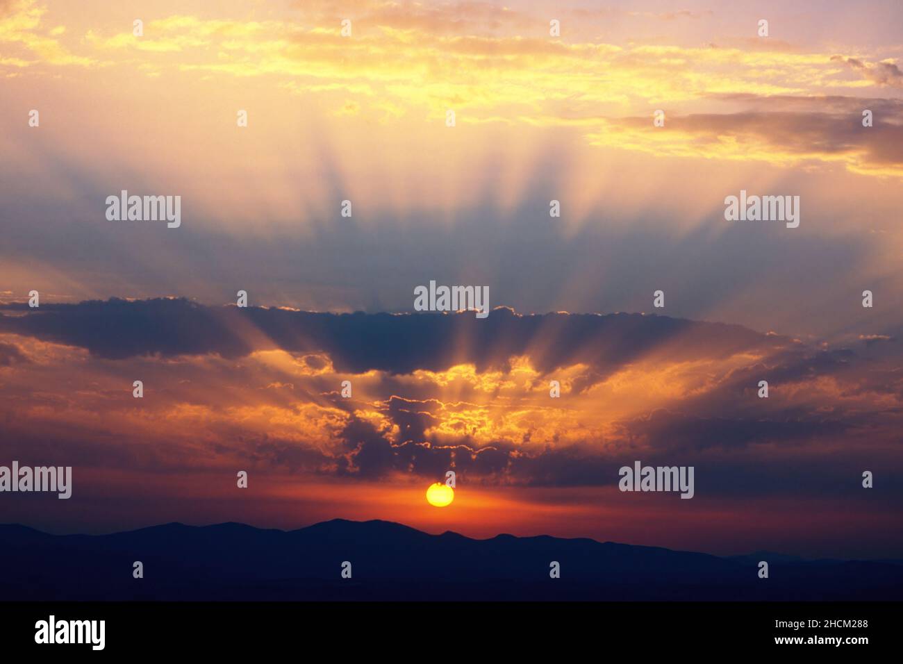 les rayons lumineux entre les nuages créent un spectaculaire coucher de soleil automnal Banque D'Images