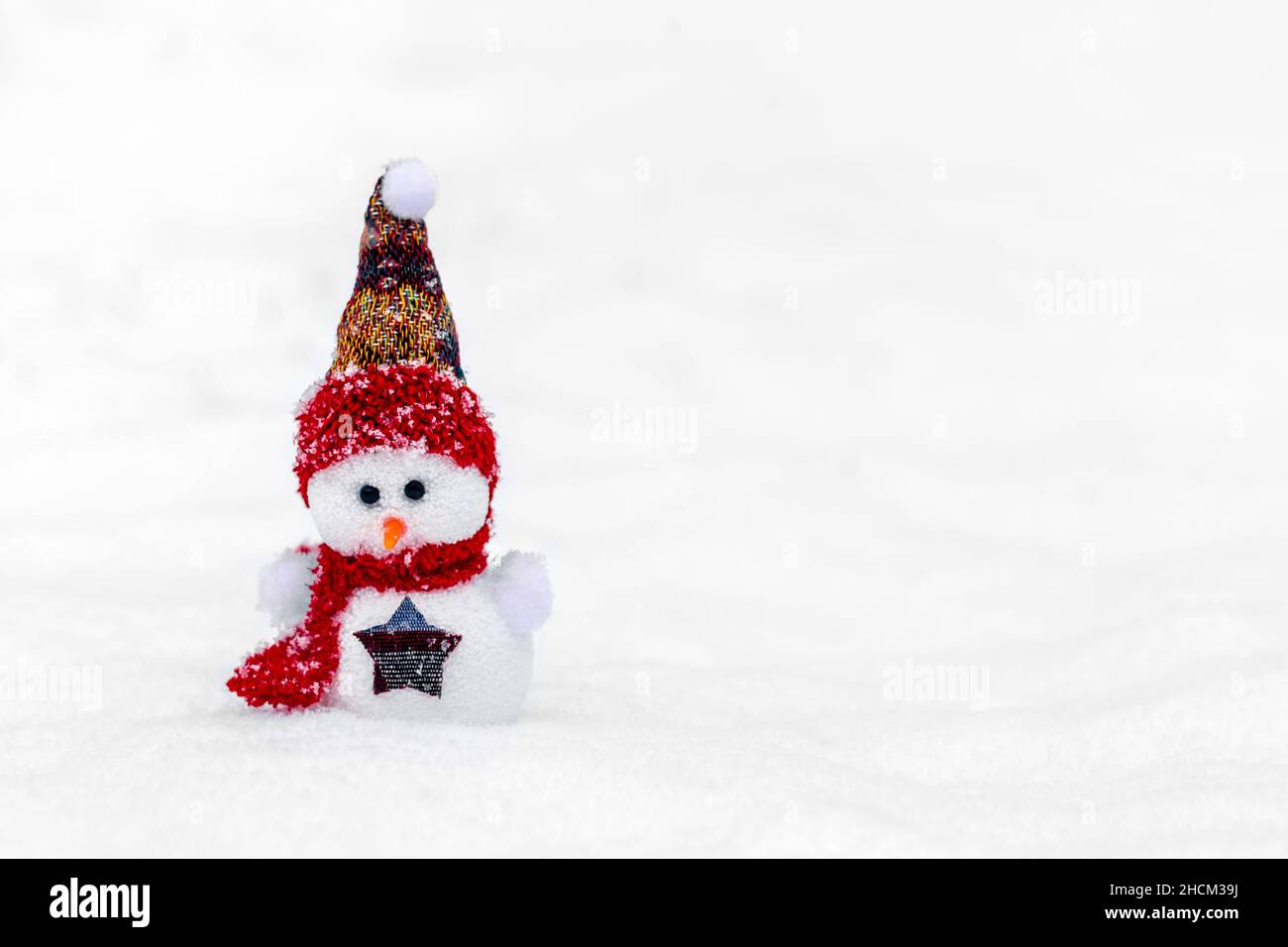 Joyeux noël et bonne année carte de voeux avec espace copie deux petits bonshommes de neige heureux en rouge, bleu casquette et écharpe debout dans le fond de neige d'hiver Banque D'Images
