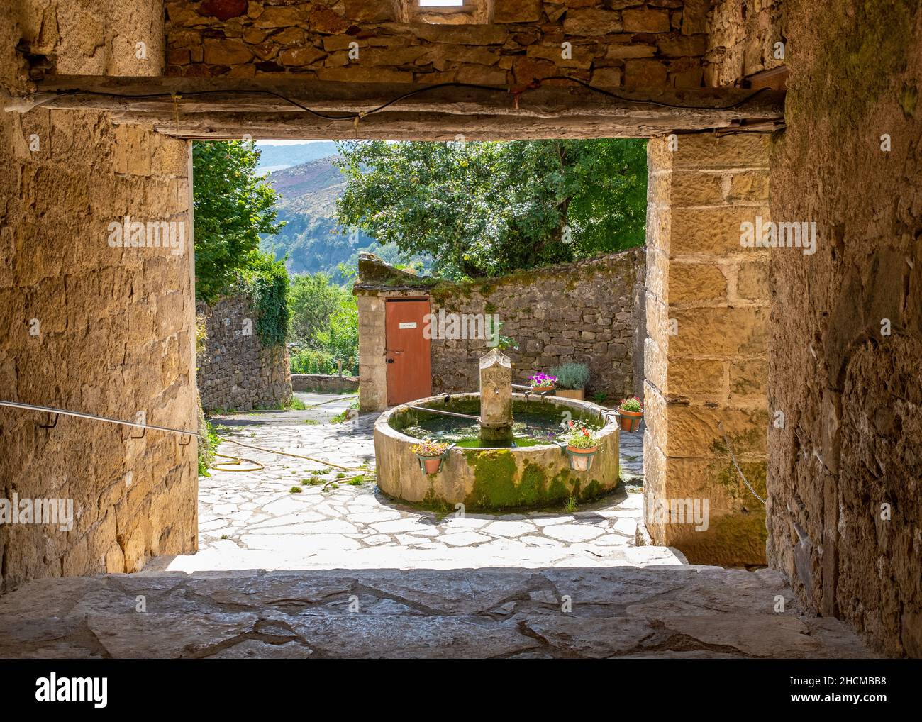 Fontaine vue à travers un porche situé dans le village de barre-des-Cévennes, (sud de la France), pris un matin d'été ensoleillé sans personne Banque D'Images