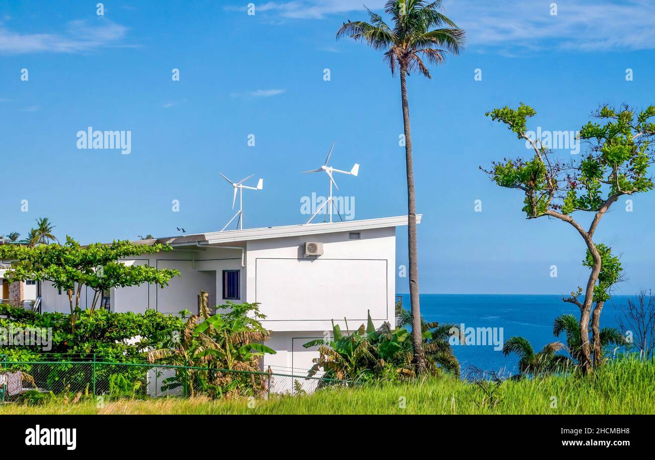 Une maison avec deux éoliennes résidentielles installées sur son toit pour la production d'énergie, sur l'île Mindoro aux Philippines. Banque D'Images