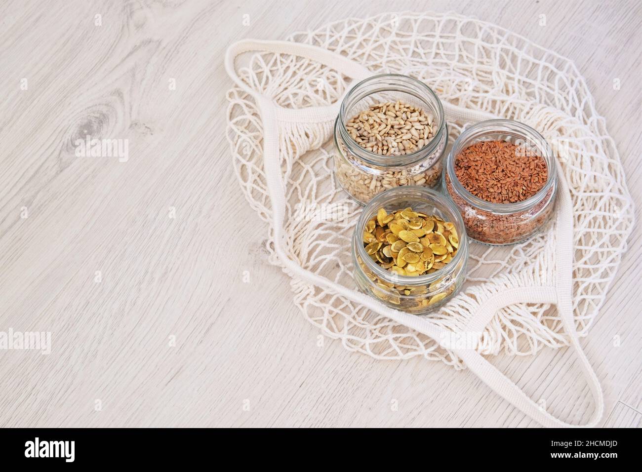 Graines biologiques dans zéro magasin de déchets.Graines de lin, tournesol et potiron en pots de verre sur fond de bois.Style de vie à faible gaspillage.Copier l'espace. Banque D'Images