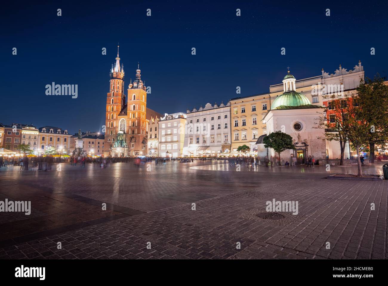 Place du marché principale la nuit avec la basilique Sainte-Marie et l'église Saint-Wojciech - Cracovie, Pologne Banque D'Images