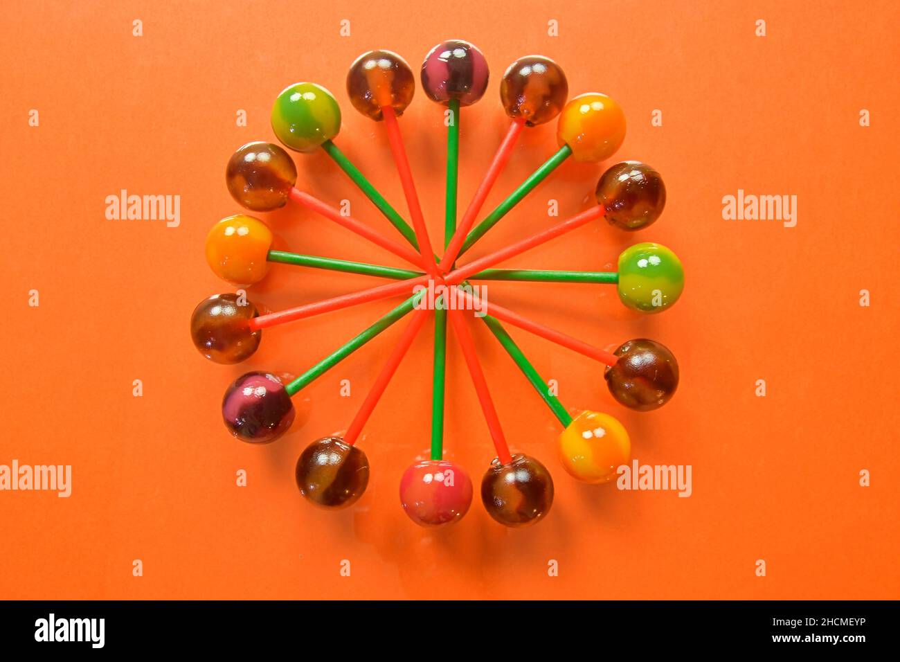 Plusieurs sucettes colorées sur fond pastel.Des sucettes juteuses de couleur vive sur fond orange.Sucettes sous forme de fleur.Gâteau aux fruits Banque D'Images