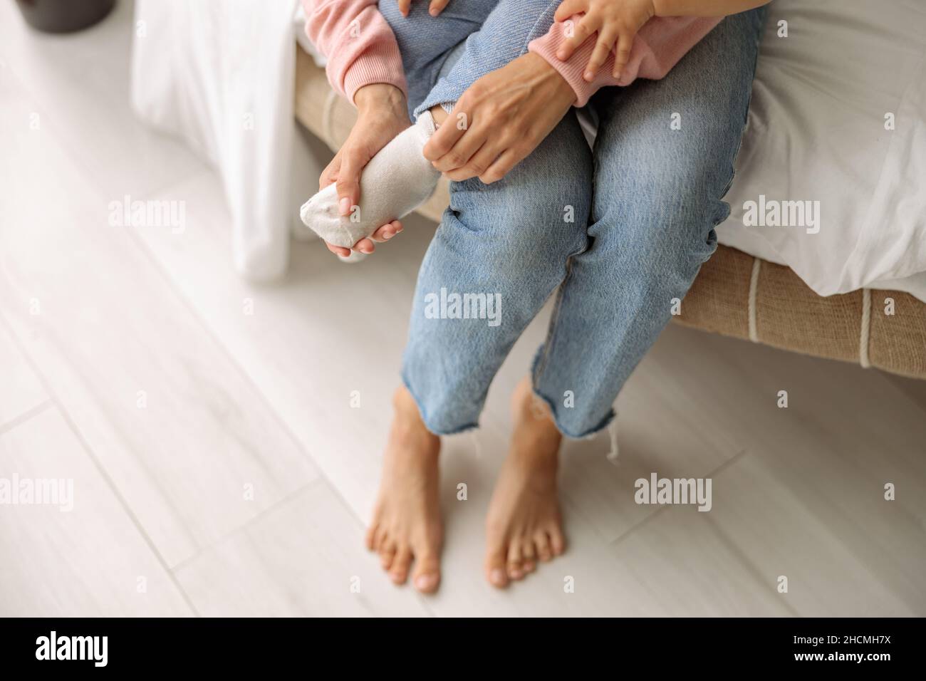 Maman mettant les chaussettes sur son petit fils Banque D'Images