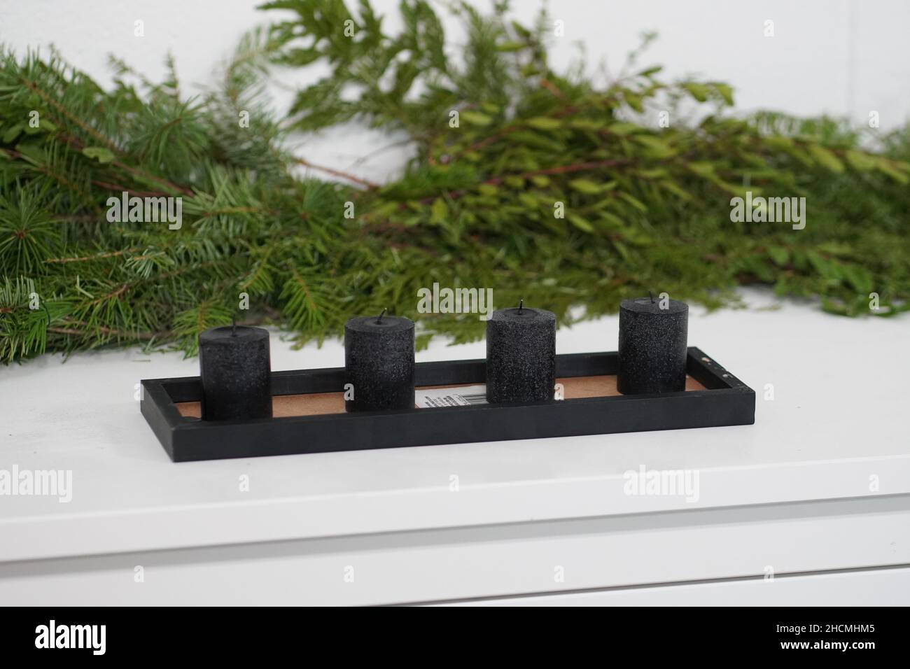 Ensemble de bougies noires avec branches d'arbre de Noël en arrière-plan Banque D'Images