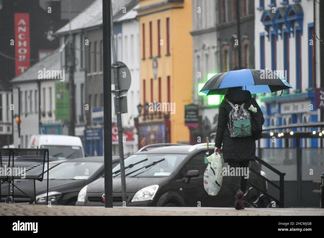 Bantry, West Cork, Irlande.130H décembre 2021.Met Eireann a publié un avertissement météorologique jaune pour Cork, en prévision de fortes pluies qui conduiront à des inondations localisées.Photo ci-dessous : femme marchant sous la pluie tout en tenant un parapluie.Credit: Karlis Dzjamko News/Alay Live News Banque D'Images