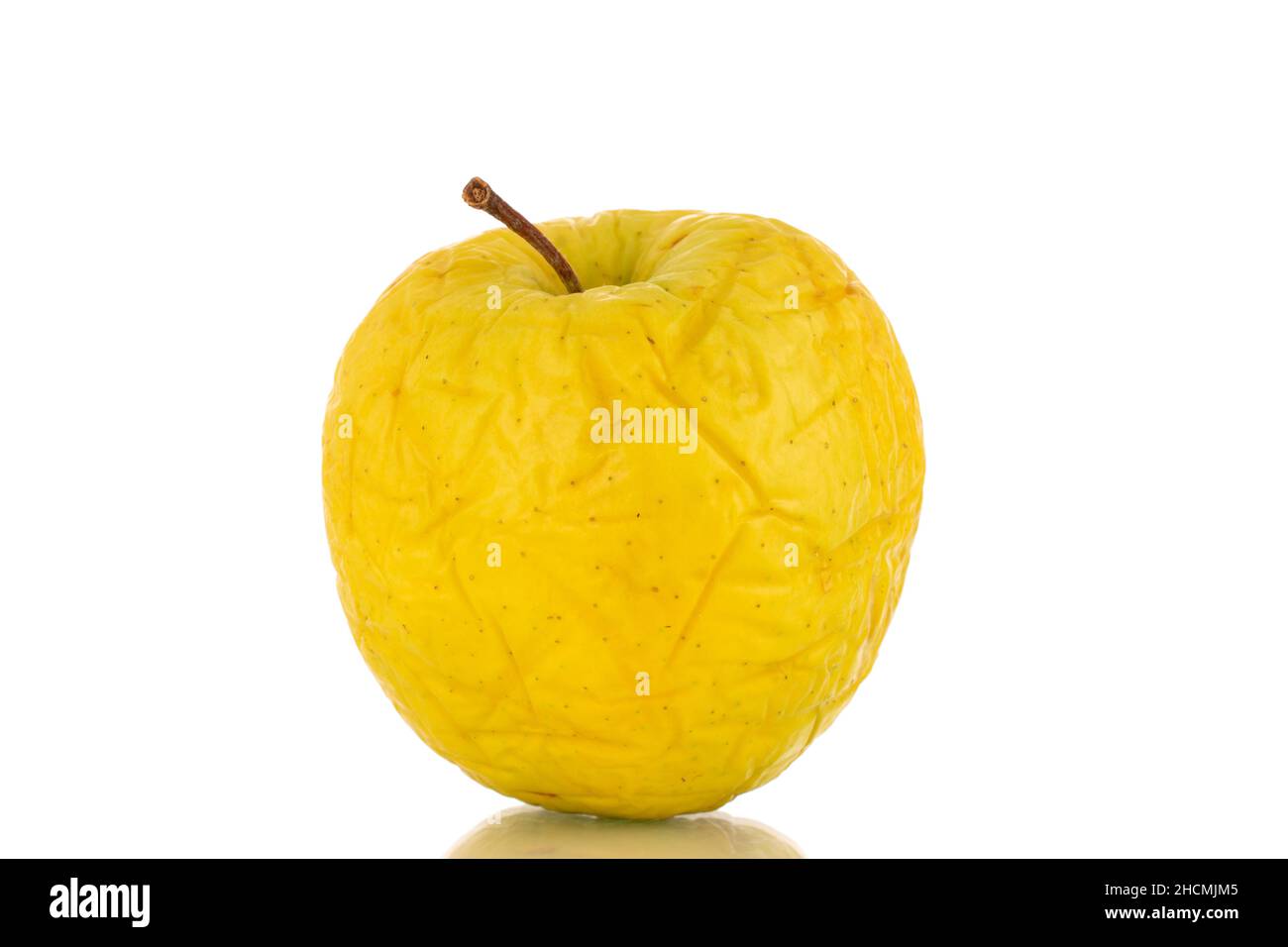 Une pomme jaune pas très fraîche, en gros plan, isolée sur blanc. Banque D'Images