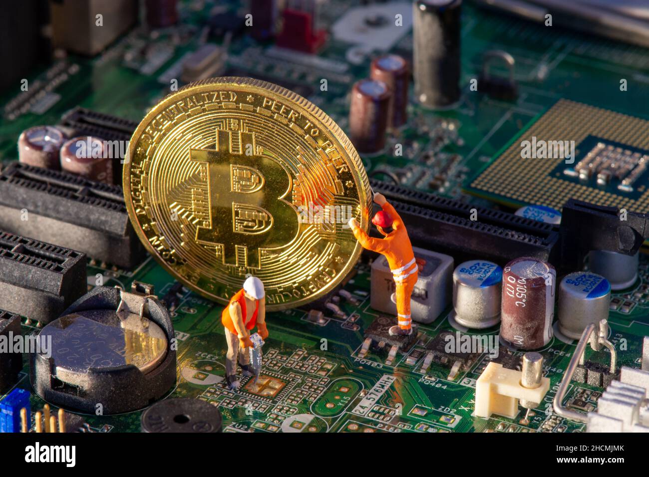 Extraction de bitcoin à l'intérieur d'un ordinateur.Deux petits mineurs de Bitcoin figurines d'extraction de précieuses crypto-monnaies numériques extraites électroniquement de la carte mère Banque D'Images