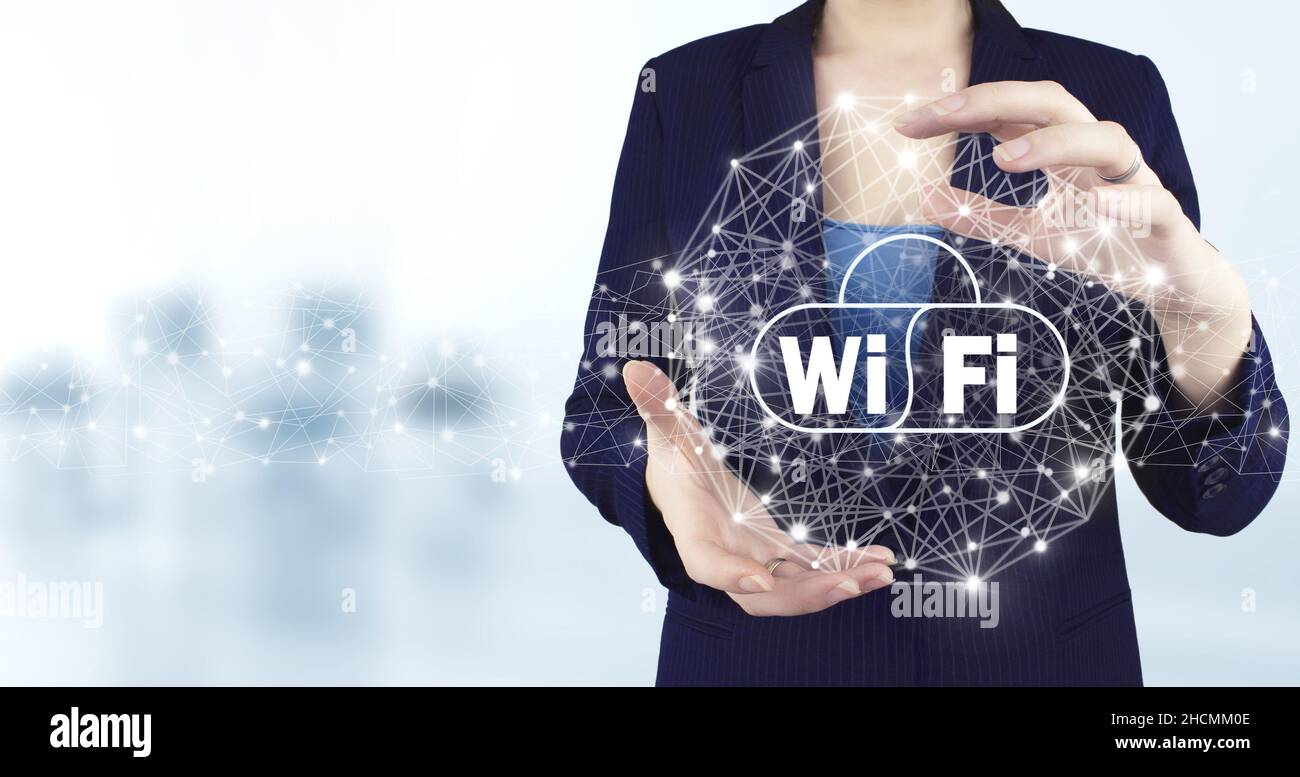 Concept de connexion réseau d'entreprise et Wi-Fi en ville.Icône Wi Fi holographique virtuelle à deux mains avec arrière-plan flou.WiFi gratuit Banque D'Images