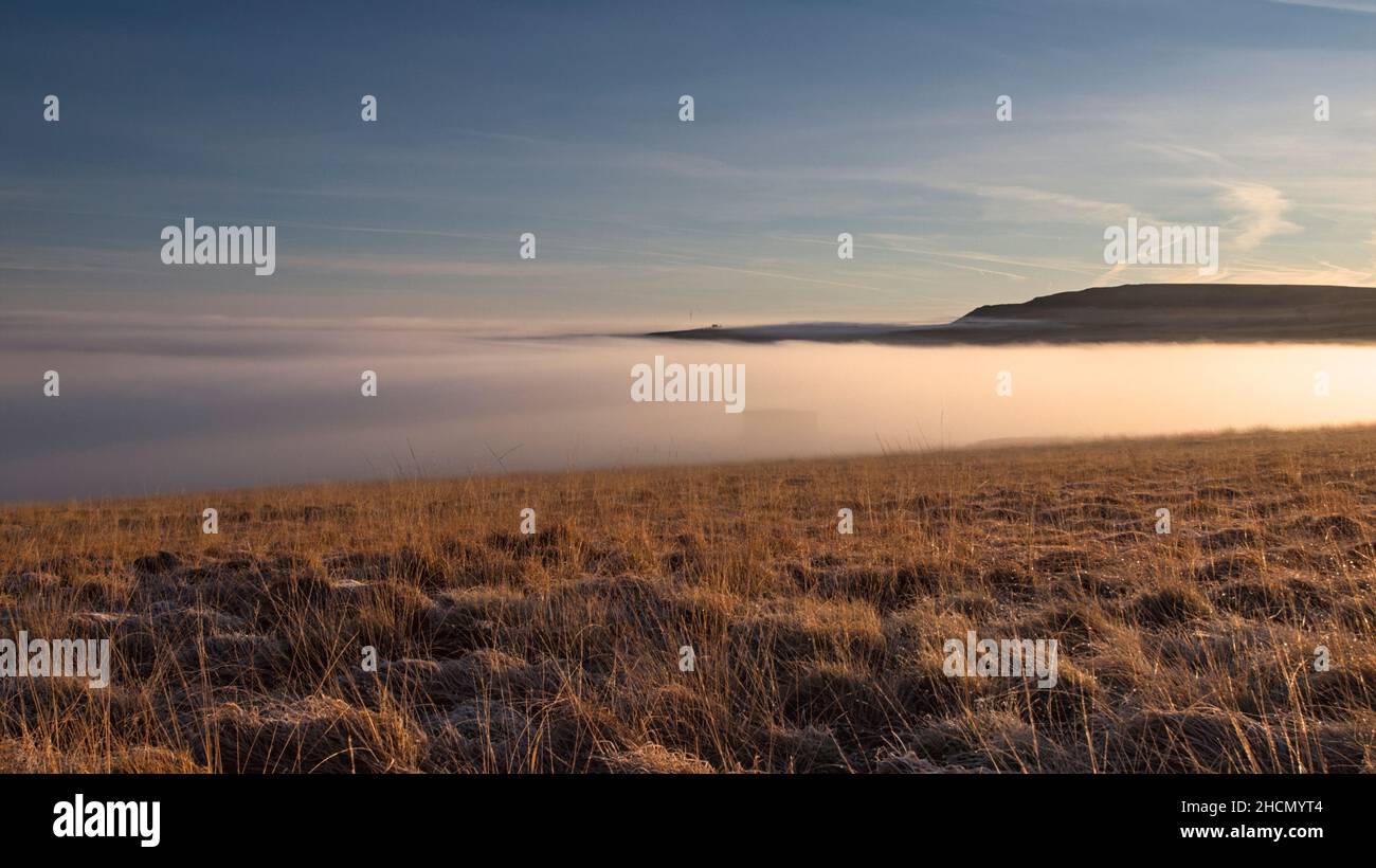 Brume dans la vallée de Colne avec le mât de télévision d'Emley à la distance du chemin de pied à l'aéroglisseur à Pule Bents, Marsden. Banque D'Images
